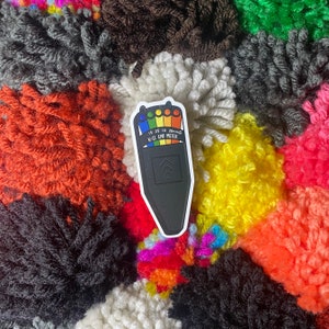 May include: A black and white sticker of a Kill-It-Meter, a device used to measure the intensity of a hangover. The meter has a rainbow scale with numbers 5, 10, 15, 20, and 25. The text "Kill-It Meter" is printed below the scale.