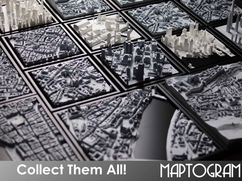 May include: A collection of framed 3D printed cityscapes in black frames. The text "Collect Them All!" and "MAPTOGRAM" are visible at the bottom of the image.