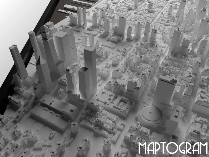 May include: A 3D model of a city skyline with tall buildings and a circular structure in the center. The model is made of white plastic and is set against a white background. The word "MAPTOGRAM" is printed in black at the bottom of the image.