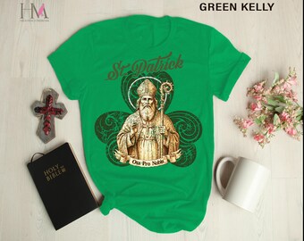 May include: Green t-shirt with a graphic of Saint Patrick in a shamrock. The graphic includes the text "Ora Pro Nobis".