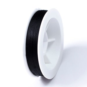 May include: A spool of black thread wound around a white plastic bobbin.