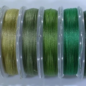 May include: Ten spools of green and blue thread, each wound on a clear plastic spool.
