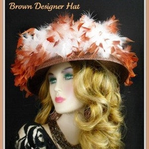 May include: A brown wide-brimmed hat with white and orange feathers. The hat is decorated with a large cluster of feathers on the top.