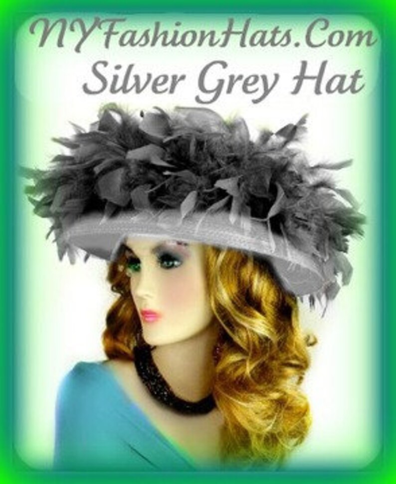 May include: A silver grey hat with a large black feather trim. The hat is made of a soft, silky material and has a wide brim.