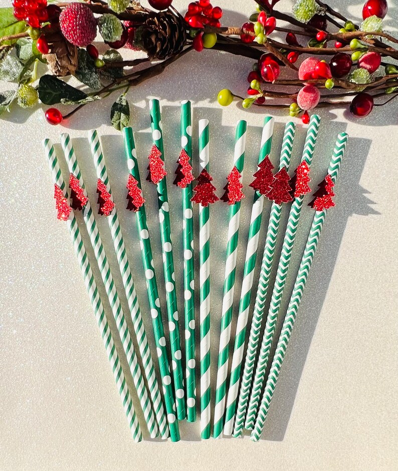 May include: A set of 12 green and white striped paper straws with red glitter Christmas tree toppers. The straws have different patterns, including polka dots, stripes, and chevron.