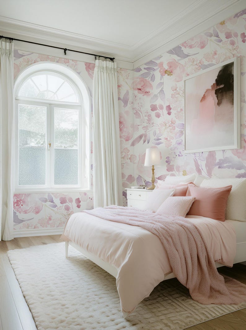 May include: A bedroom with a white bed, pink bedding, and a fluffy pink throw. The walls are decorated with floral wallpaper in shades of pink and purple. A large window with white curtains and a white rug complete the room.