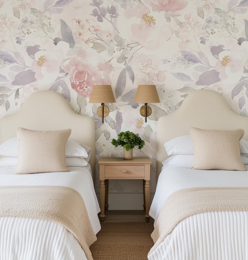 May include: Two twin beds with white bedding, beige headboards, and matching pillows. A small wooden nightstand with a green plant sits between the beds. Floral wallpaper and woven lampshades complete the bedroom decor.