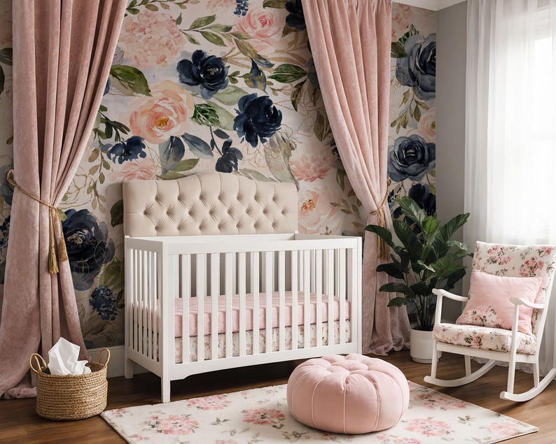 May include: A white crib with a tufted beige headboard, a pink sheet, and a floral skirt. The room features floral wallpaper, pink velvet curtains, a pink tufted ottoman, a white rocking chair with a floral cushion, and a woven basket with white fabric.