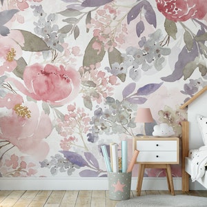 May include: Watercolor floral wallpaper in shades of pink, purple, and gray creates a soft, artistic backdrop. The room features a white bed frame, a pink flamingo plush, and a two-drawer nightstand with a pink lamp.