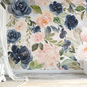 May include: A floral wallpaper featuring large watercolor roses in navy blue and blush pink, with gold accents. The room includes a white canopy, a dreamcatcher, and a small table with wooden chairs, creating a soft, inviting space.
