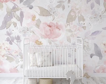 May include: A white crib with a pink and gray floral wallpaper behind it. The crib has a white mattress and a white pillow with the text "Grand & Night" on it. There is a rocking horse in the foreground.