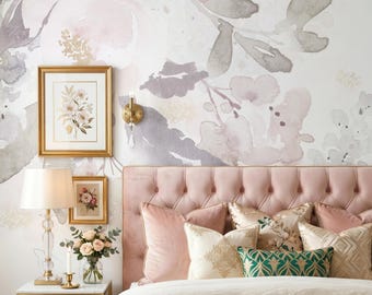 May include: A tufted pink velvet headboard with assorted decorative pillows in pink, cream, and green patterns. A bedside table holds a crystal lamp, a vase of roses, and a candle. Two framed floral prints hang on a wall with a large floral mural.