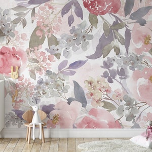 May include: Watercolor floral wallpaper in shades of pink, purple, and gray. The design features large peony blooms and smaller floral clusters. A white dresser, wooden chair, and decorative items are in the foreground.