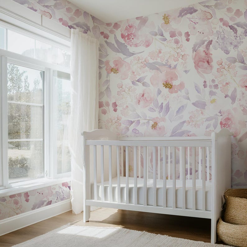 May include: A white crib in a nursery with floral wallpaper in shades of pink and purple. A window with white curtains is on the left. A woven basket is on the right. The room has a soft, inviting atmosphere.