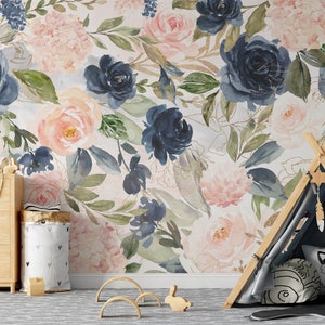 May include: A floral wallpaper featuring large watercolor roses in shades of navy, blush pink, and peach, with green leaves and gold accents. The room includes a wooden dresser, a teepee, and decorative items.
