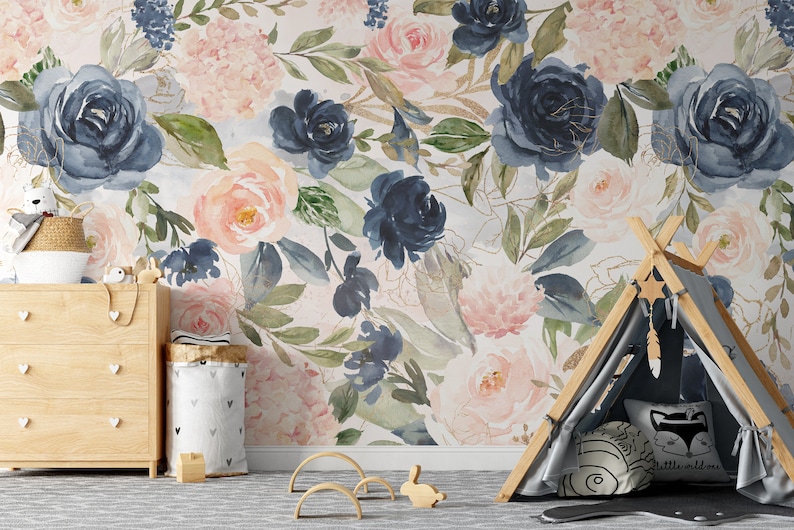 May include: A floral wallpaper featuring large watercolor roses in shades of navy, blush pink, and peach, with green leaves and gold accents. The room includes a wooden dresser, a teepee, and decorative items.