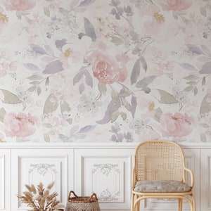 May include: A floral wallpaper featuring watercolor-style pink and purple flowers and green leaves. Below, a white paneled wall with decorative accents, a woven chair, and two woven baskets filled with dried plants.
