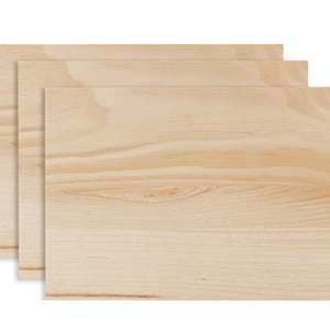 May include: Three rectangular wooden boards with a light, natural wood grain pattern. The boards are stacked slightly offset, revealing their edges. The wood has a warm, light brown color with visible grain and knots.