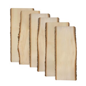 May include: Six rectangular wooden planks with natural bark edges. The planks are light beige with a smooth surface and a rough, textured edge. The planks are arranged in a staggered, slightly angled pattern against a white background.