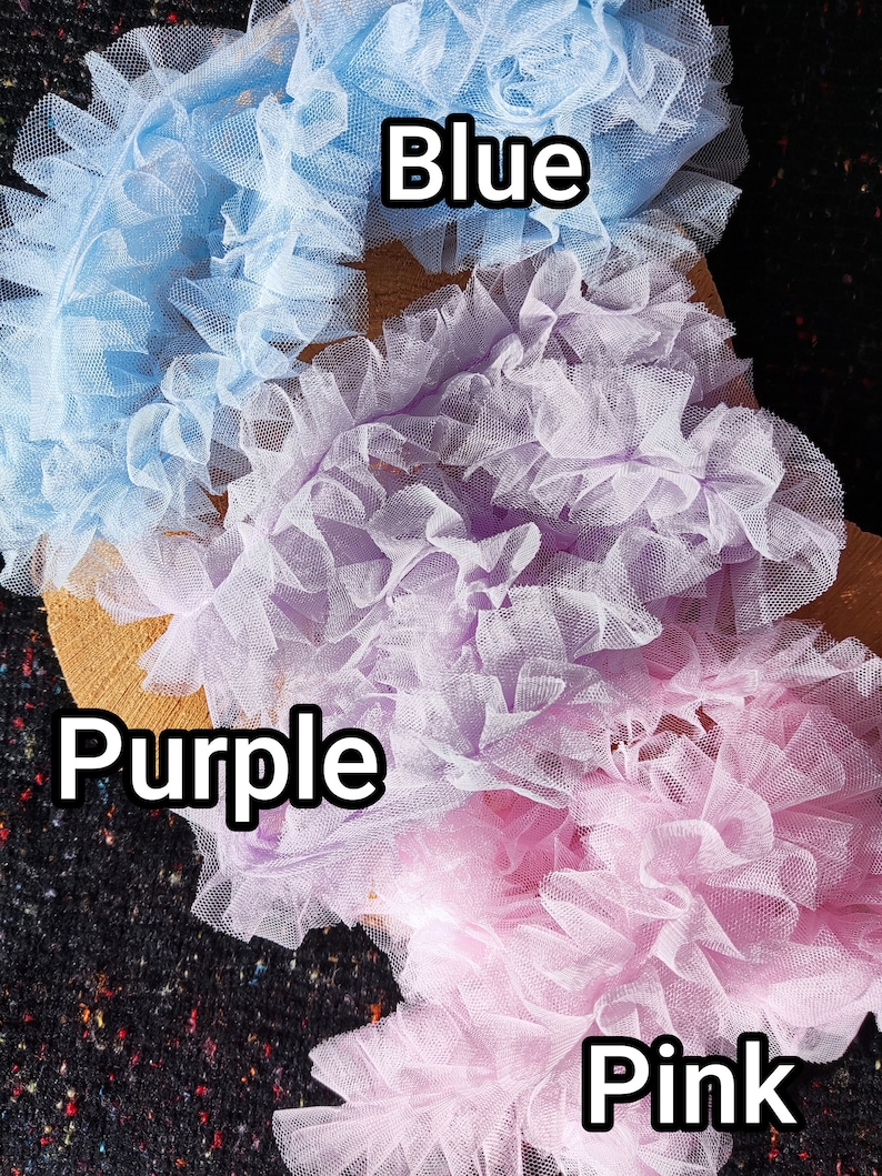 Pu&ograve; includere: Tre strisce di tessuto in tulle arricciato in azzurro, viola chiaro e rosa chiaro. Ogni striscia presenta una consistenza densa e increspata. Il testo Blue, Purple e Pink &egrave; stampato sull'immagine per identificare ogni colore del tulle.