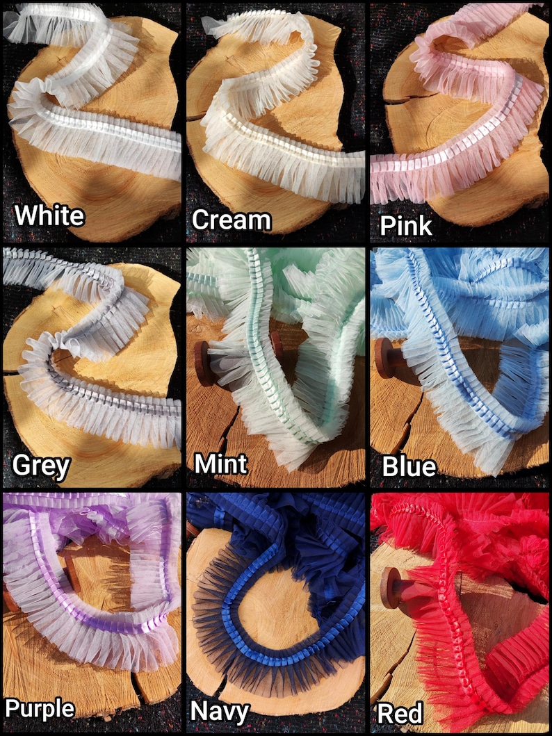 May include: A collage of colorful ruffled trim samples. Colors include white, cream, pink, grey, mint, blue, purple, navy, and red. Each trim is displayed on a wooden slice, showcasing the texture and variety of the fabric.