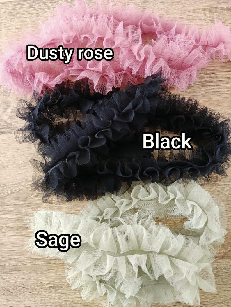Pu&ograve; includere: Tre strisce di nastro in tulle arricciato disposte in file orizzontali. Il nastro superiore &egrave; rosa polvere, quello centrale &egrave; nero e quello inferiore &egrave; color salvia. Ogni pezzo presenta una consistenza pieghettata in tessuto a rete fine.