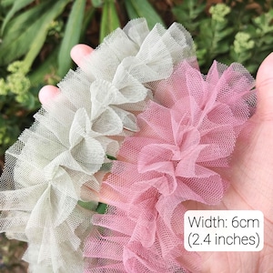 Pu&ograve; includere: Due strisce di bordo in tulle arricciato nei colori verde salvia e rosa antico. Il tessuto a rete presenta una consistenza pieghettata e arricciata lungo il centro. Un'etichetta bianca sull'immagine mostra il testo Width: 6cm (2.4 inches).