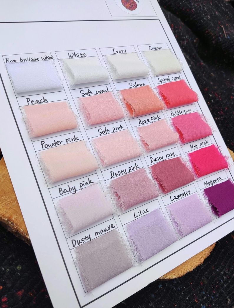 Puede incluir: Una carta de colores con veinte muestras de tela dispuestas en una cuadr&iacute;cula sobre una hoja blanca. Cada muestra est&aacute; etiquetada con texto escrito a mano que incluye Pure brilliant white, White, Ivory, Cream, Peach, Soft coral, Salmon, Spiced coral, Powder pink, Soft pink, Rose pink, Bubblegum, Baby pink, Dusty pink, Dusty rose, Hot pink, Dusty mauve, Lilac, Lavender y Magenta.