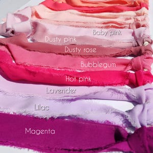 Puede incluir: Una colecci&oacute;n de cintas de tela con bordes deshilachados, dispuestas en un degradado de tonos rosas y morados. Las cintas est&aacute;n etiquetadas con el texto: Baby pink, Dusty pink, Dusty rose, Bubblegum, Hot pink, Lavender, Lilac y Magenta.