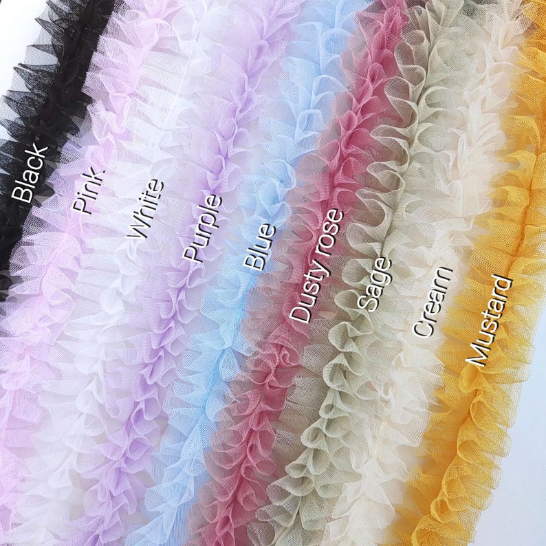 Pu&ograve; includere: Una collezione di strisce di bordo in tulle arricciato disposte verticalmente in vari colori, tra cui nero, rosa, bianco, viola, blu, rosa antico, salvia, crema e senape. Ogni striscia &egrave; etichettata con il nome del colore in bianco.