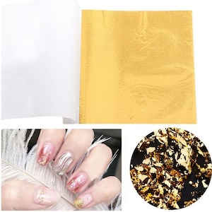 Pu&ograve; includere: Fogli di foglia d'oro per nail art, con un foglio di trasferimento bianco e un primo piano di una mano con disegni di unghie in foglia d'oro.