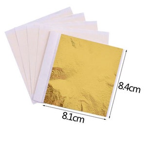 Pu&ograve; includere: Un foglio di foglia d'oro che misura 8,1 cm per 8,4 cm. La foglia d'oro &egrave; su un foglio di supporto bianco.