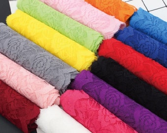 Può includere: Una collezione di pizzi di diversi colori, tra cui bianco, rosa, rosso, viola, blu, nero, grigio, giallo e verde. Il pizzo ha un motivo floreale.