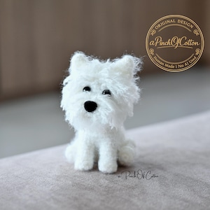 May include: A small, white, fuzzy West Highland White Terrier figurine with black eyes and a black nose. The figurine features a circular logo in the upper right corner with the text Original Design aPinchOfCotton Human Made I No AI Used.