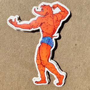 May include: A sticker featuring a muscular, orange, cartoon-like creature with a long snout, wearing blue patterned swim trunks. The creature is flexing its arm, showcasing its physique. The sticker has a white border.