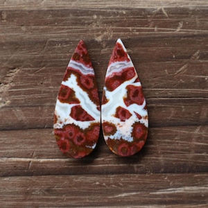 May include: A white ceramic mug with a black handle and the text "But First, Coffee" in a bold, black font. The mug is set against a blurred background, suggesting a cozy setting. The mug appears to be approximately 4 inches tall.