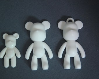 May include: Three white plastic bear figurines of varying sizes. The bears are simple and have no facial features.