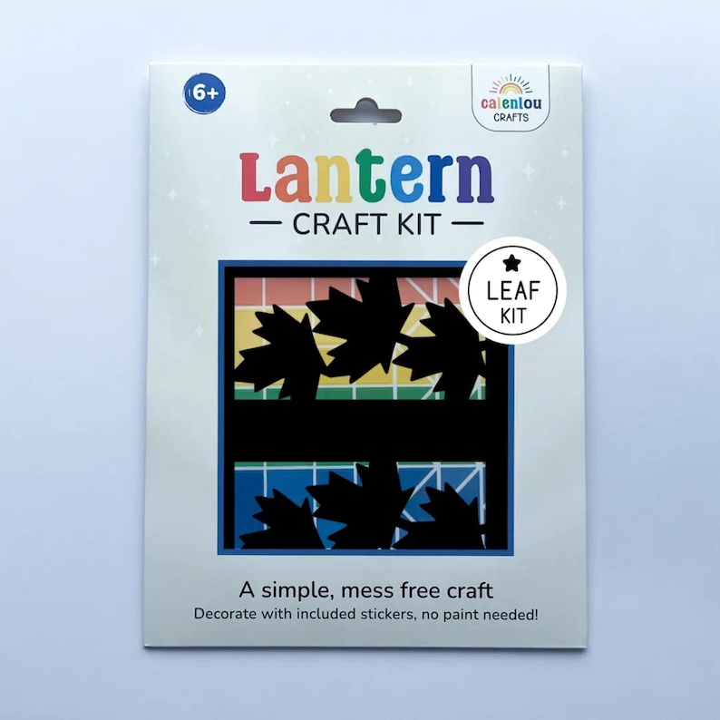 May include: A craft kit for making a leaf-themed lantern. The package features the words "Lantern CRAFT KIT" in colourful letters. The design includes black leaf cutouts and the text "A simple, mess free craft. Decorate with included stickers, no paint needed!"