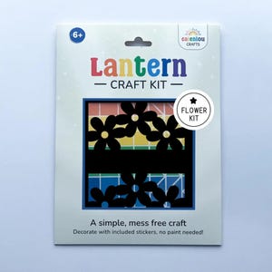 May include: A craft kit for making a lantern, featuring a flower design. The kit includes stickers and requires no paint. The package has the text "Lantern - CRAFT KIT - Flower Kit" and is suitable for ages 6+.