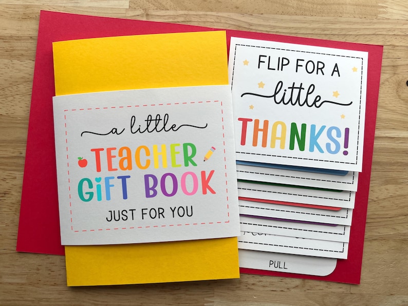 May include: A teacher gift book with a yellow cover and a red envelope. The book has the text "a little TEACHER GIFT BOOK JUST FOR YOU" and "FLIP FOR A little THANKS!" in colorful letters. The book has pull-out cards.