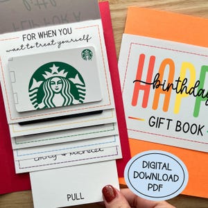 May include: A gift book with a Starbucks gift card. The cover reads "Happy Birthday GIFT BOOK" in colorful letters. The gift card is white with a green Starbucks logo. The pull-out section says "For when you want to treat yourself."