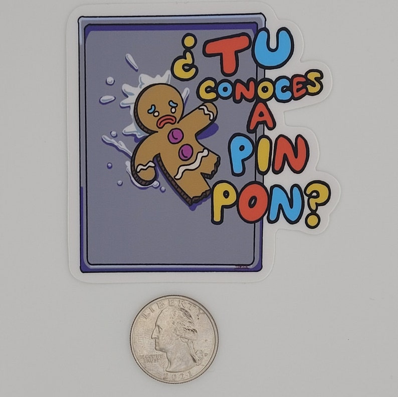 May include: A sticker featuring a cartoon gingerbread man with a sad expression, lying on a gray surface with a splash effect. The text "&iquest;TU CONOCES A PIN PON?" is in colorful letters.