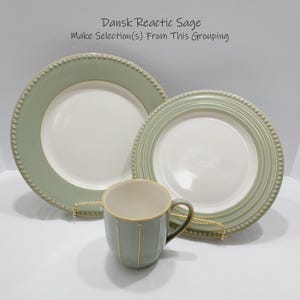 May include: Two round ceramic plates and one mug in sage green and cream. The plates feature a beaded rim detail. The mug has vertical stripes and a handle. Text at the top reads: Dansk Reactic Sage. Make Selection(s) From This Grouping.