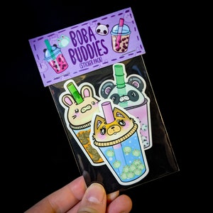 May include: A sticker pack with three cute animal boba tea designs. The stickers feature a panda, a bunny, and a fox holding boba tea cups. The sticker pack is labeled "Boba Buddies (Sticker Pack)".