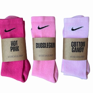 Op de afbeelding: Drie paar Nike sokken in verschillende roze tinten. De sokken zijn gelabeld met "Hot Pink", "Bubblegum" en "Cotton Candy".