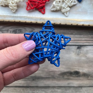 May include: A blue woven star ornament. The star is made of thin, woven strips of material and is a deep blue color.