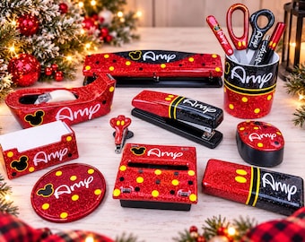 May include: A set of red and black glittery office supplies featuring yellow polka dots and the name Amy. The collection includes a tape dispenser, stapler, hole punch, pencil cup, memo holder, mouse, and various desk accessories with Mickey Mouse icons.