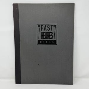 Pode incluir: Um livro retangular com capa cinza-escura e lombada preta. Centralizado na capa, há uma moldura retangular preta contendo o texto 7 PAST HEURES 7 e o nome BILAL impressos em letras maiúsculas pretas sobre um fundo cinza-claro.