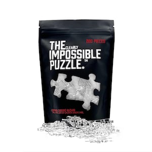Puede incluir: Una bolsa negra con una cremallera blanca que contiene un rompecabezas de plástico transparente de 200 piezas. La bolsa tiene el texto "The Clearly Impossible Puzzle" impreso en ella.