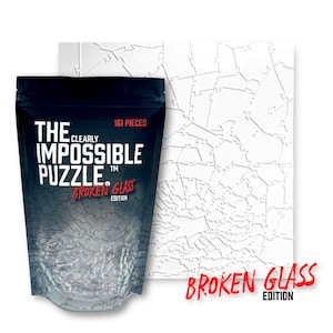May include: A black and white bag with the text "The Clearly Impossible Puzzle" and "Broken Glass Edition" on it. The bag contains a 161 piece jigsaw puzzle with a broken glass design. The puzzle is shown in the background.